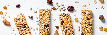 Granola bar with nuts, fruit and berries on white.